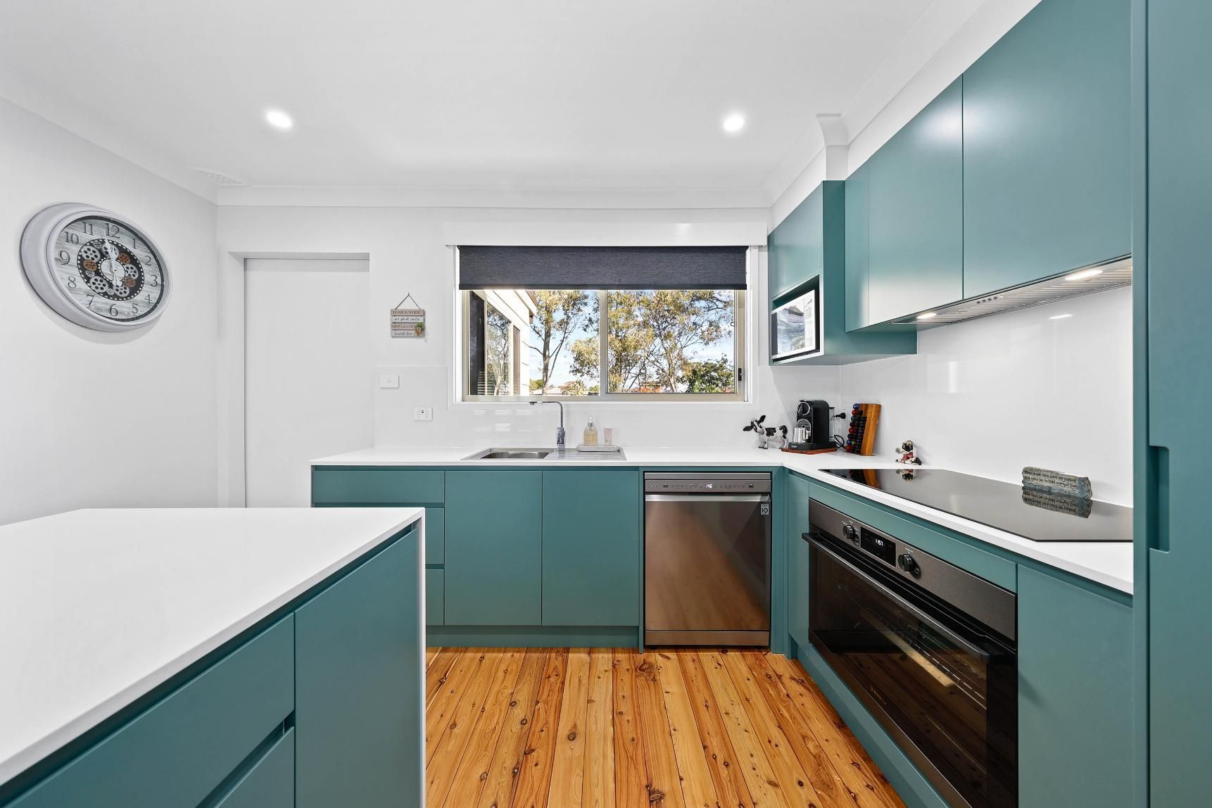 Teal Kitchen with White Countertops, Stainless Steel Appliances, and Wooden Floors — Above & Beyond Interiors Custom Joinery in Bradbury, NSW