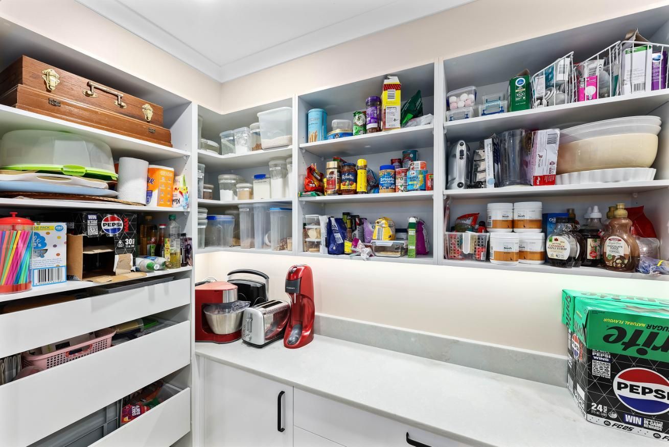 Pantry with White Shelves, Filled with Food Items, Appliances and Storage Containers. Counter Space with A Mixer and Coffee Maker — Above & Beyond Interiors Custom Joinery in Bradbury, NSW