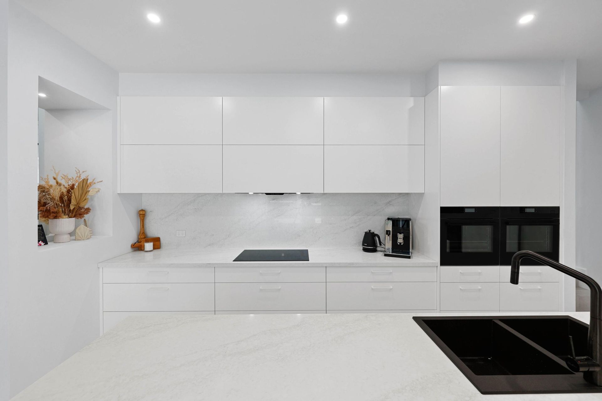Modern White Kitchen with Glossy Cabinets, Marble Backsplash, and Black Sink — Above & Beyond Interiors Custom Joinery in Currans Hill, NSW