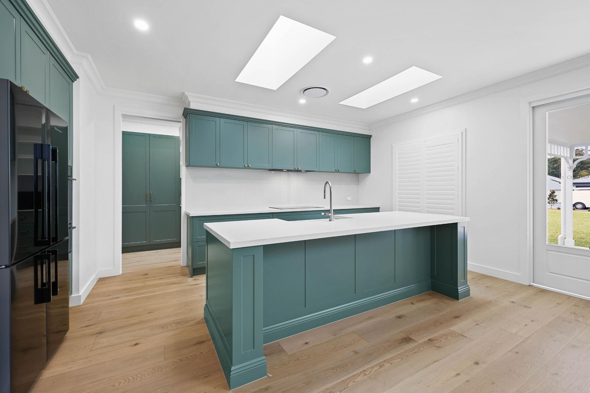 Spacious Teal Kitchen with White Countertops, Wooden Floors, and Two Skylights — Above & Beyond Interiors Custom Joinery in Appin, NSW