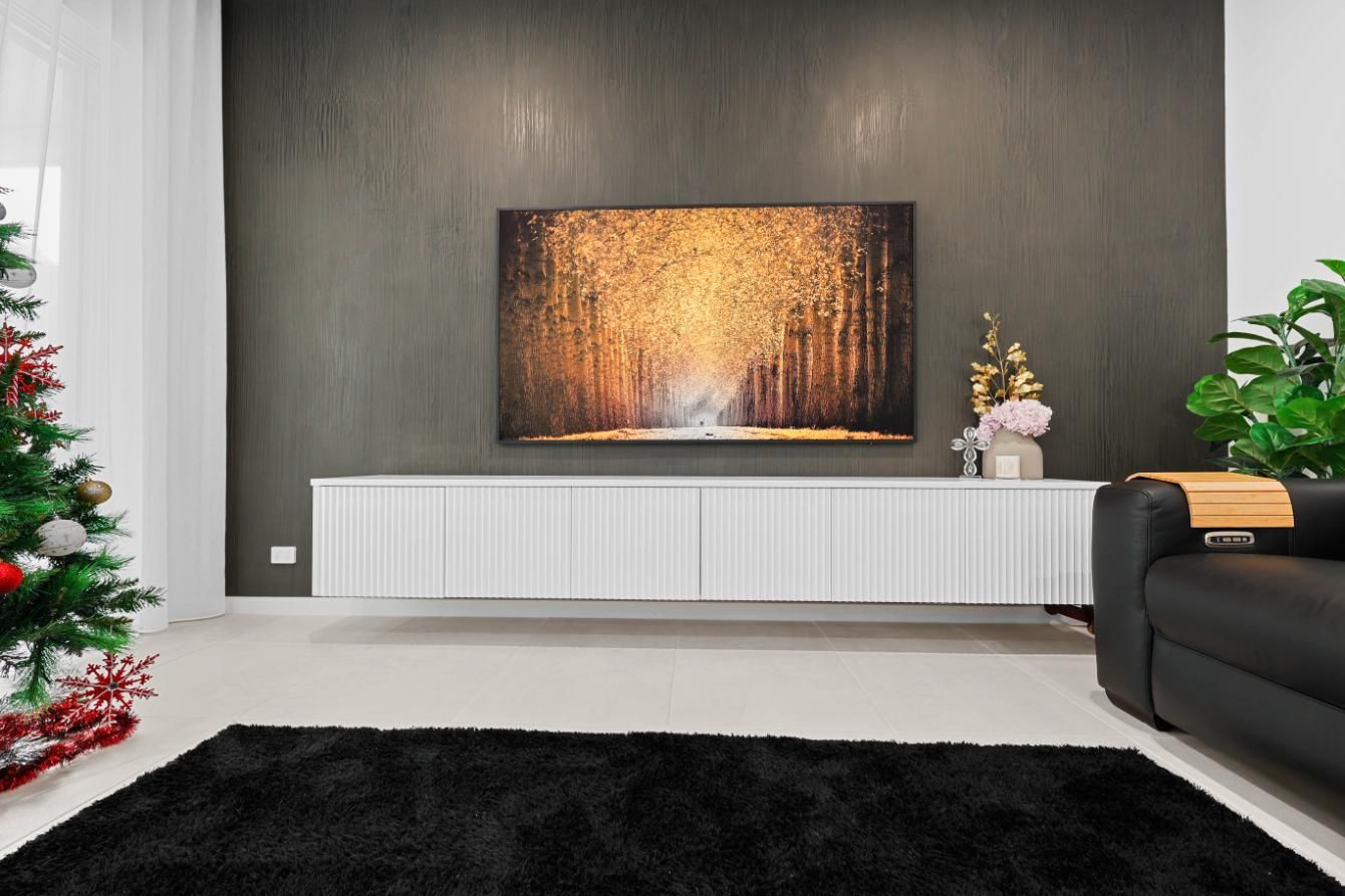 Living Room with A Black Rug, White Cabinet, Art Piece, and Black Couch. Christmas Tree on The Left — Above & Beyond Interiors Custom Joinery in Currans Hill, NSW