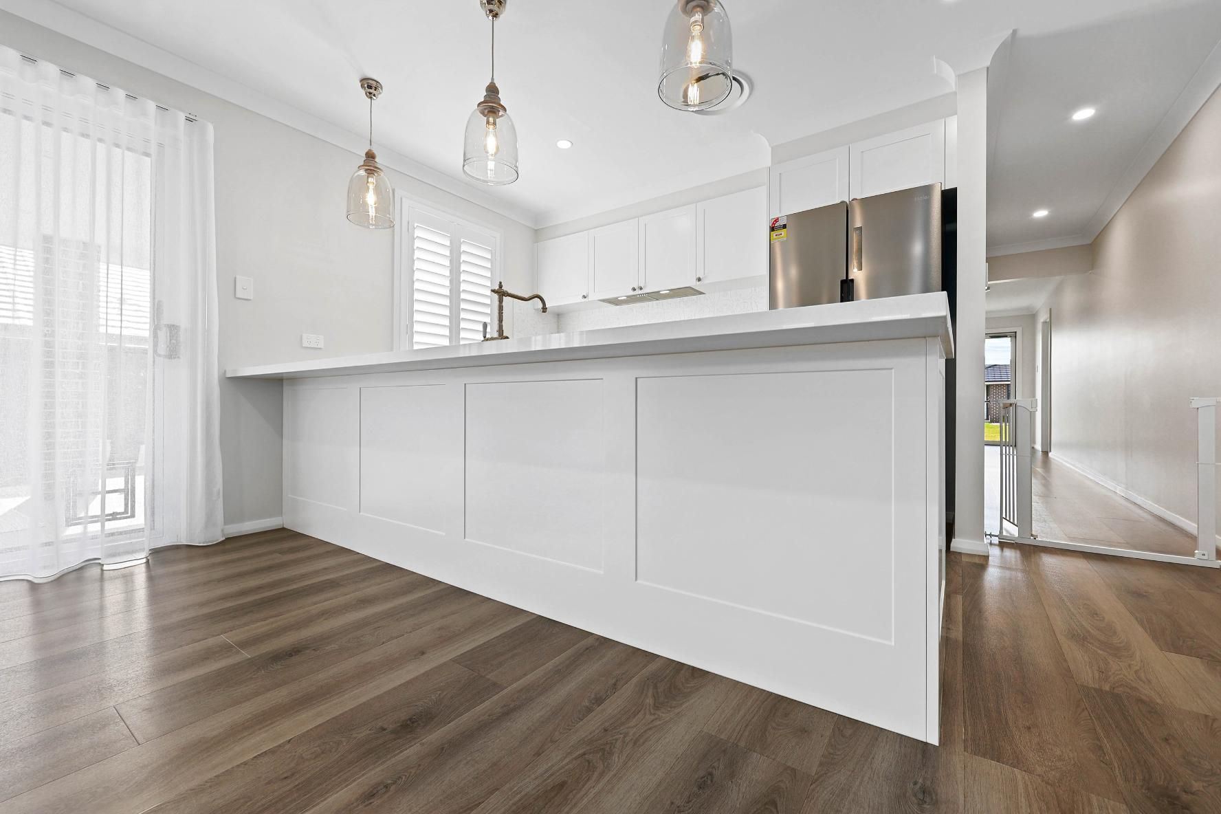 Modern White Kitchen with Stainless Steel Appliances, Hardwood Floor, and Pendant Lights — Above & Beyond Interiors Custom Joinery in Thirlmere, NSW