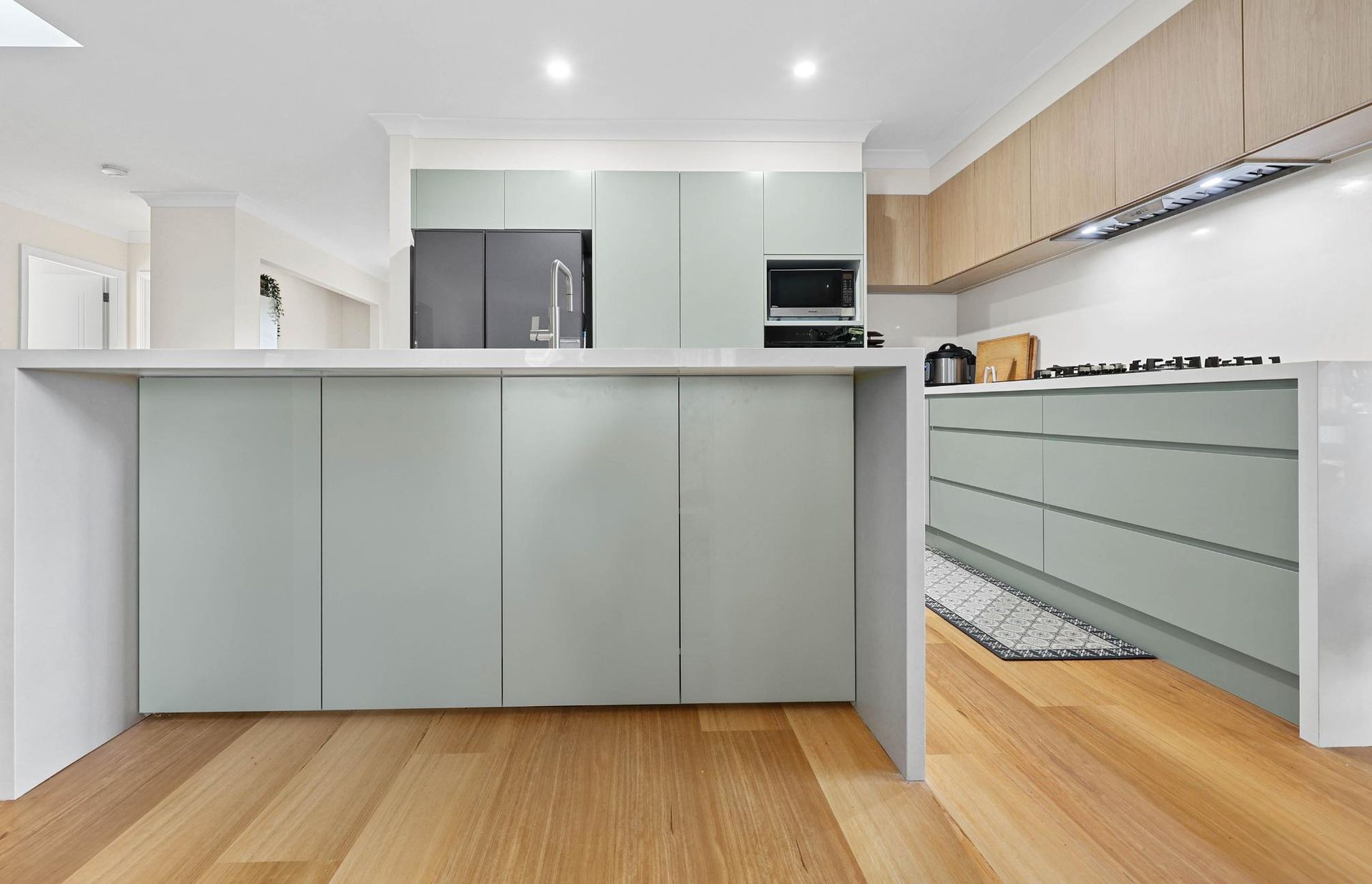 Modern Kitchen with Light Wood Floors, Light Blue Cabinets, and White Countertops — Above & Beyond Interiors Custom Joinery in Holsworthy, NSW