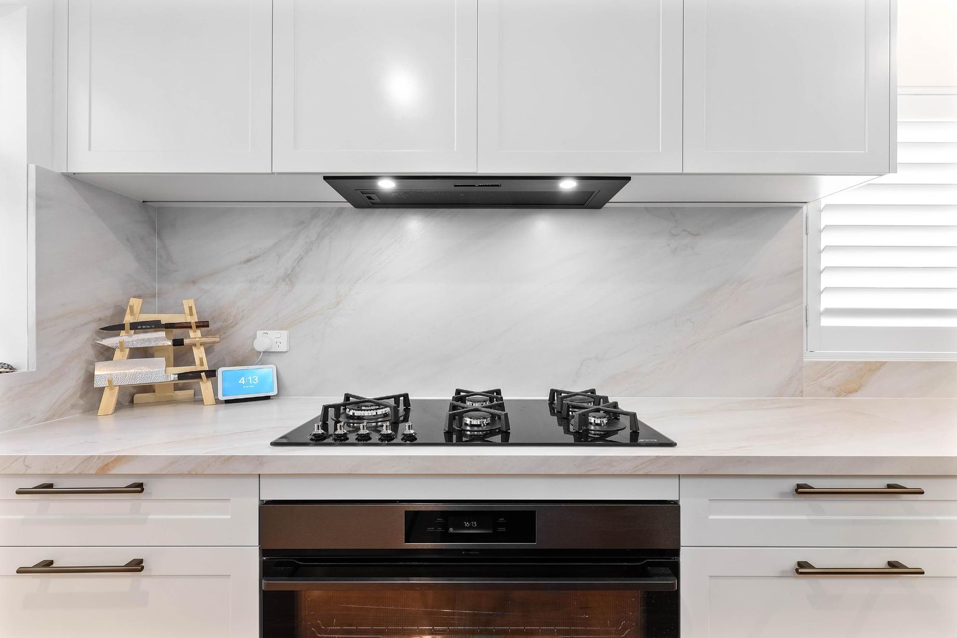 White Kitchen with Stove, Oven, and Range Hood; Marble Backsplash, Cabinets, and Countertop — Above & Beyond Interiors Custom Joinery in Bellambi, NSW