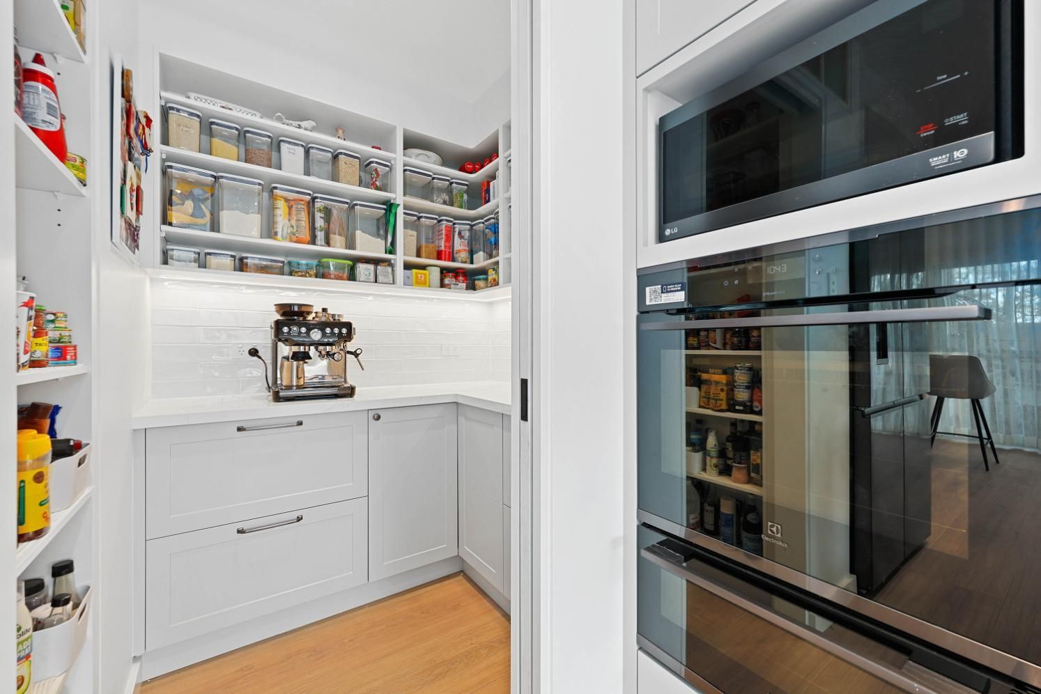 White Pantry with Shelves, Countertop, and A Coffee Machine. Microwave and Oven on The Right — Above & Beyond Interiors Custom Joinery in Yowie Bay, NSW
