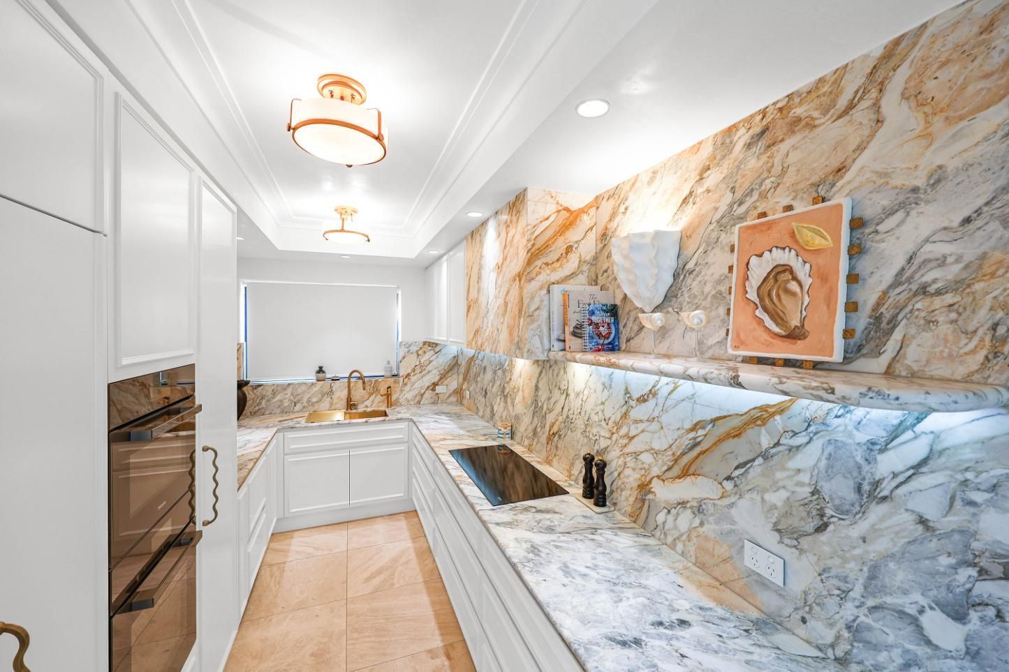 Bright Kitchen With White Cabinetry and Dramatic Marble Countertops — Above & Beyond Interiors in Smeaton Grange, NSW