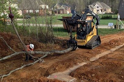 A stump grinder is cutting a tree stump in a yard.