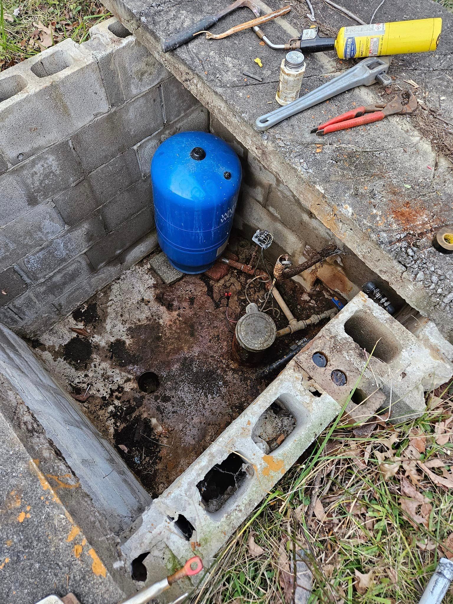 A blue cylinder is sitting in the middle of a hole in the ground.