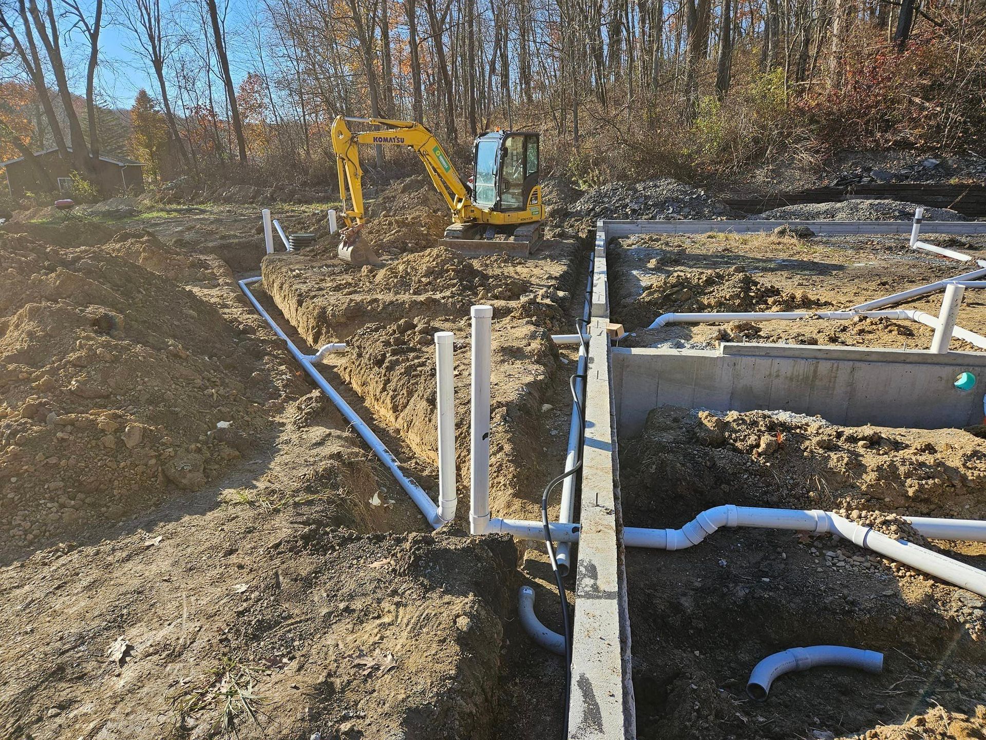 A yellow excavator is digging a hole in the ground.