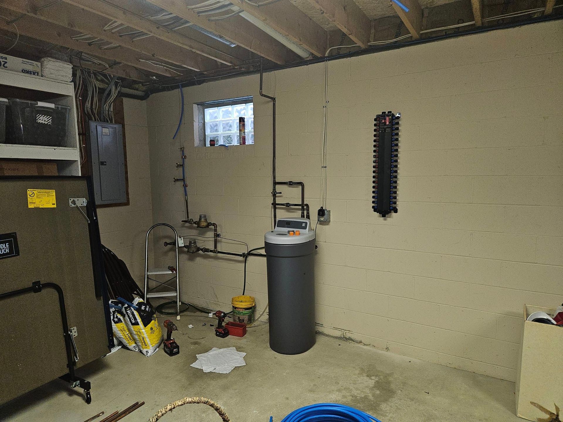 A basement with a trash can and a window