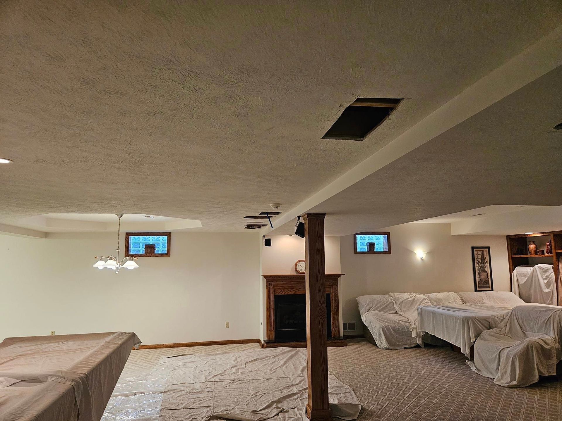 An empty basement with a pool table and a fireplace.