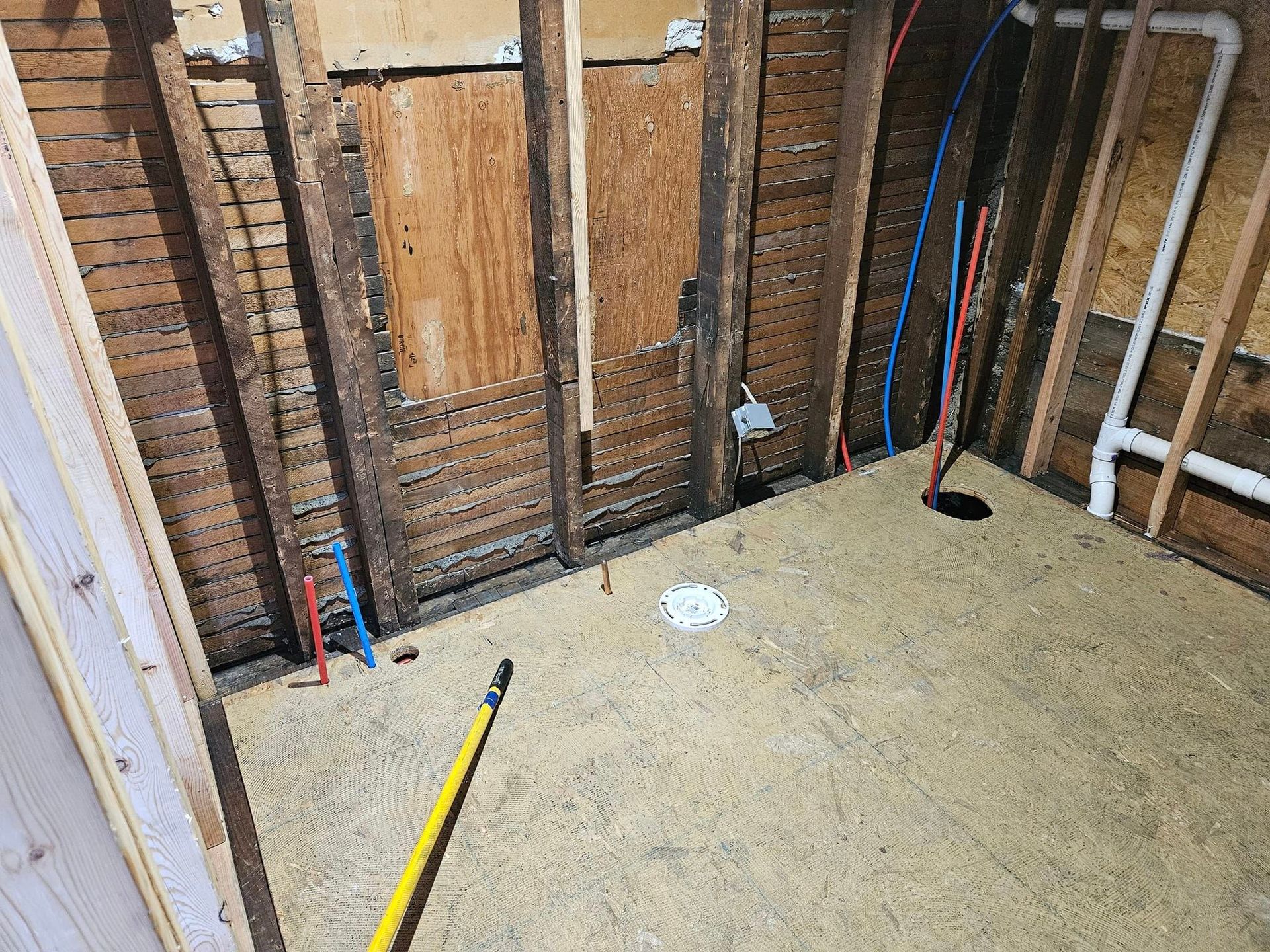 A room with wooden walls and a mop on the floor.