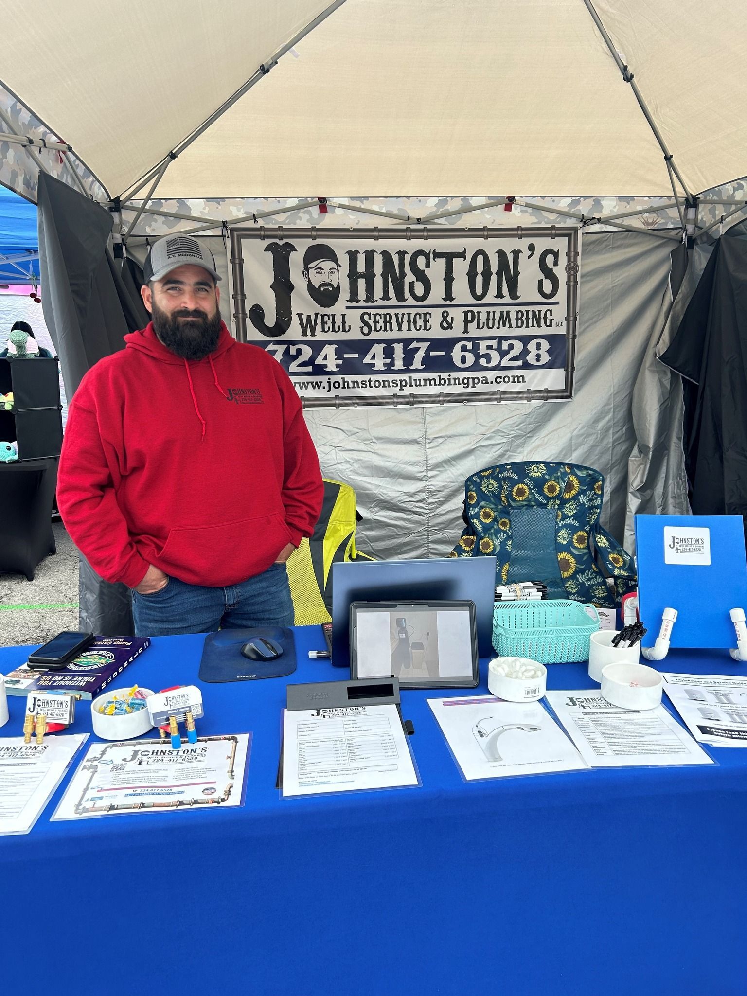 A man is standing in front of a table with a sign that says johnston 's