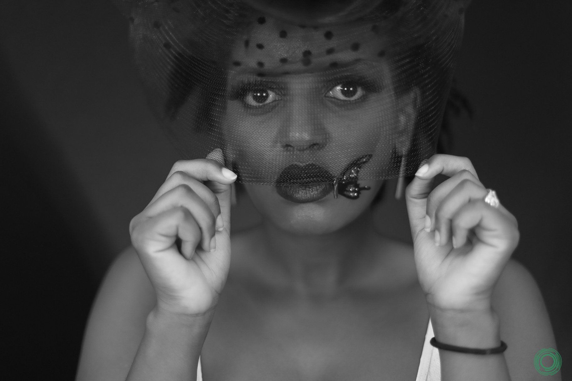 A black and white photo of a woman wearing a veil on her face.