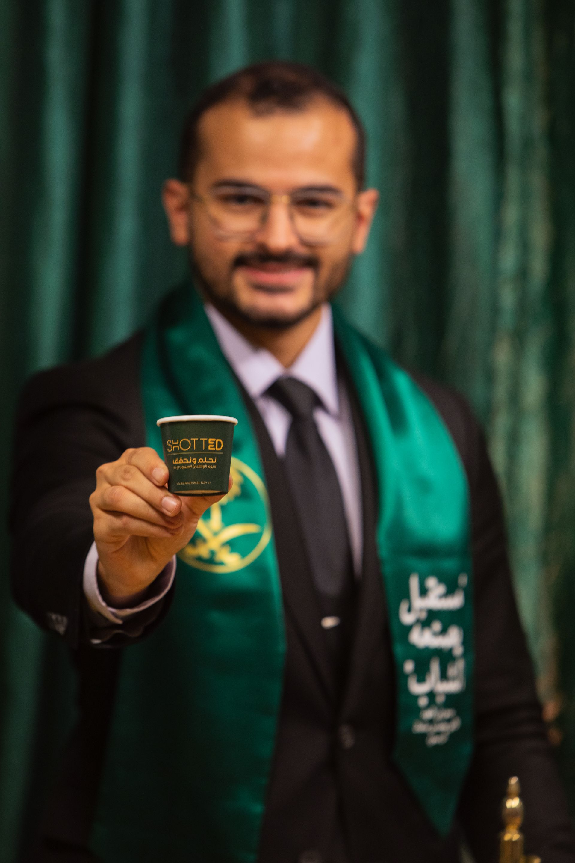 A man in a suit and tie is holding a cup of coffee