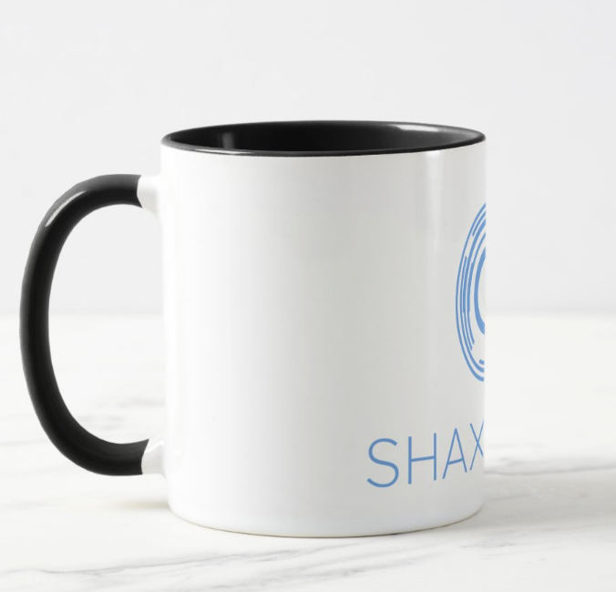 A white mug with the word shaxmedia on it
