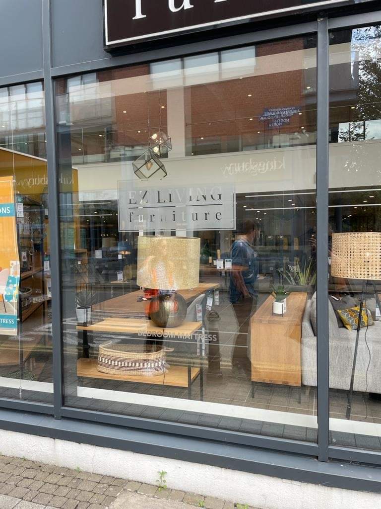 A store front with a lot of furniture in the window.