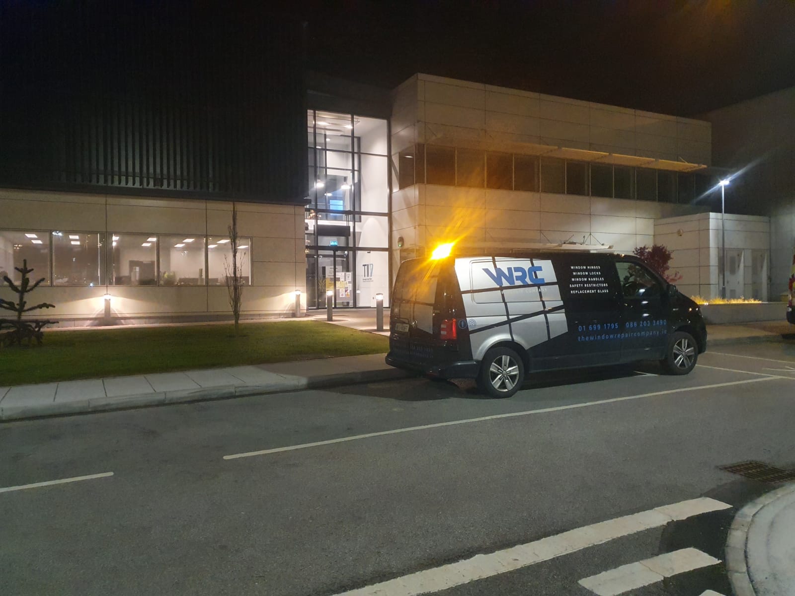 A van is parked in front of a building at night.