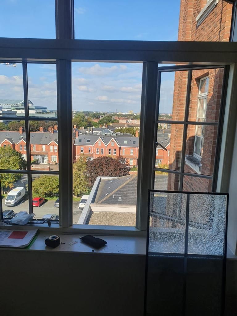 A window with a view of a city and a brick building.