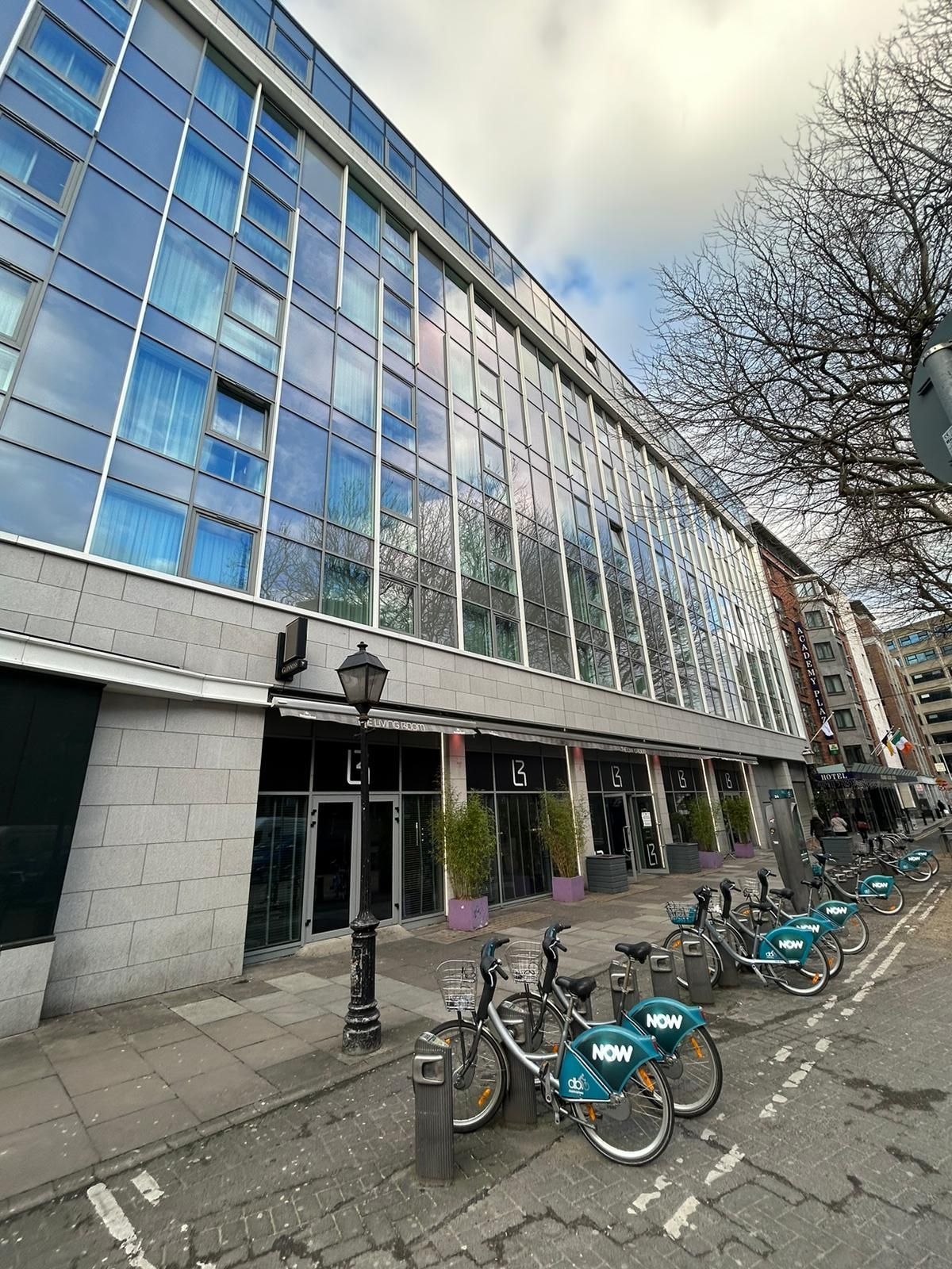 A row of bicycles are parked in front of a large building.