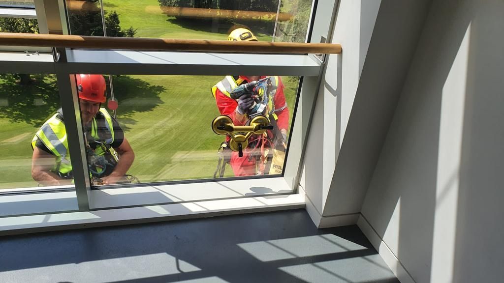 A man in a hard hat is looking out of a window.