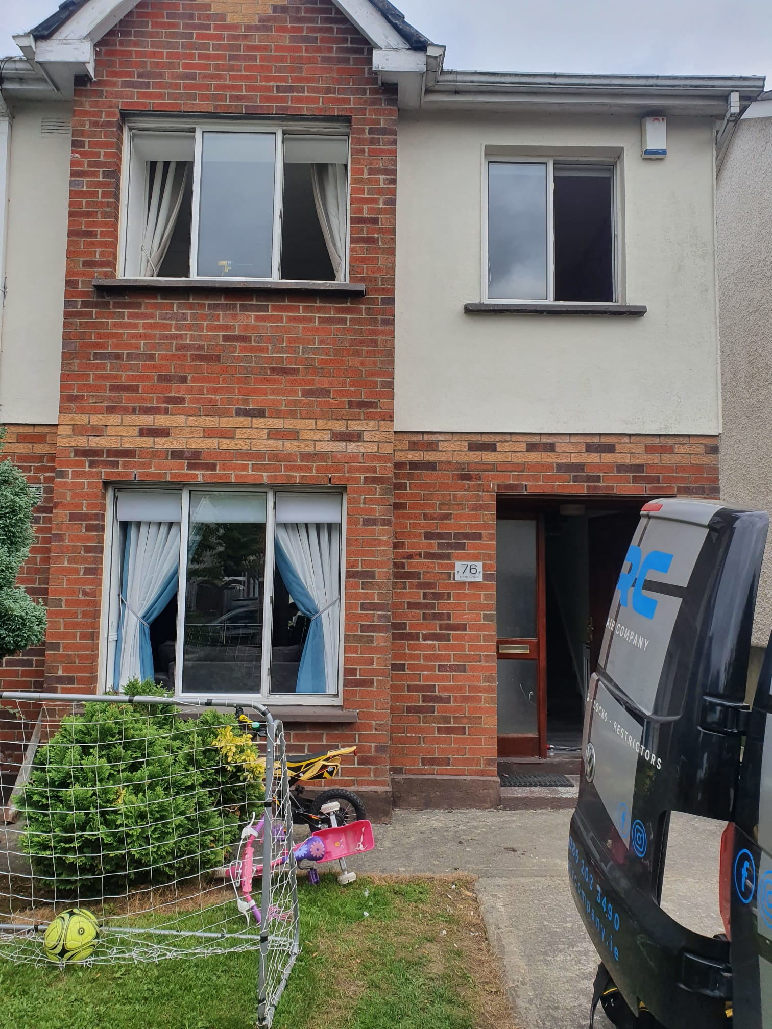 A brick house with a van parked in front of it.