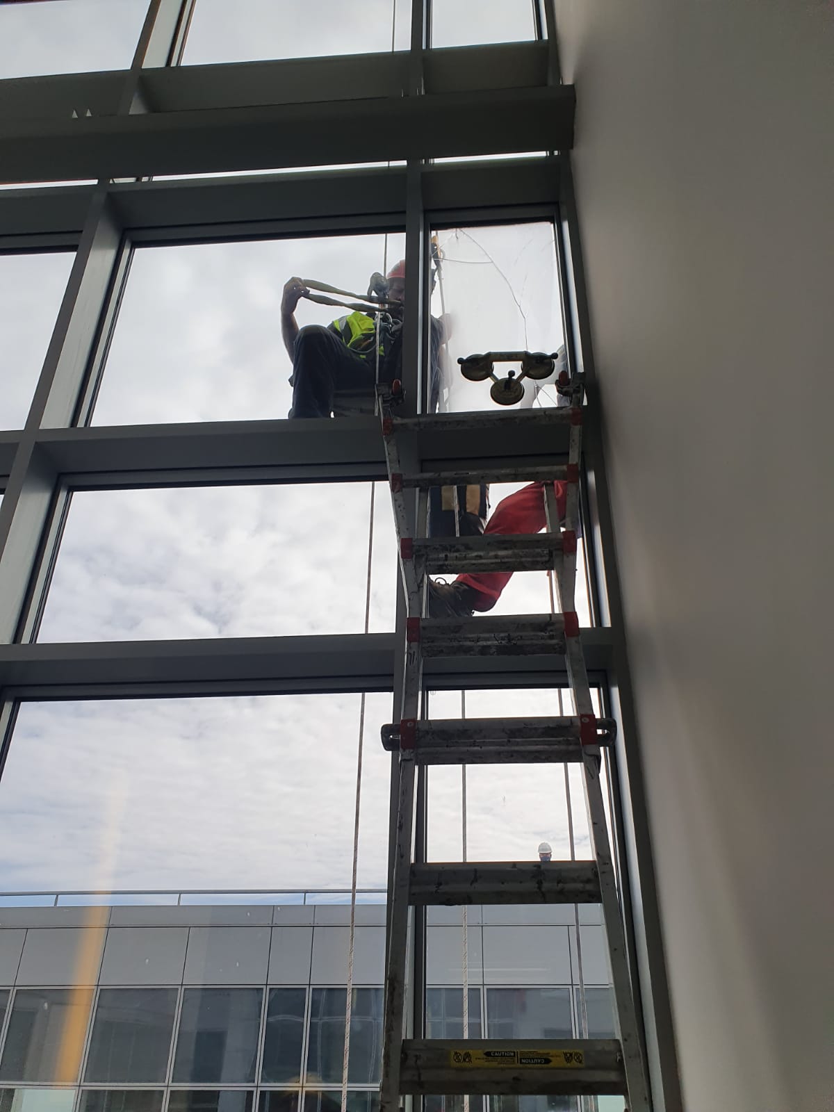 A man is standing on a ladder cleaning a window