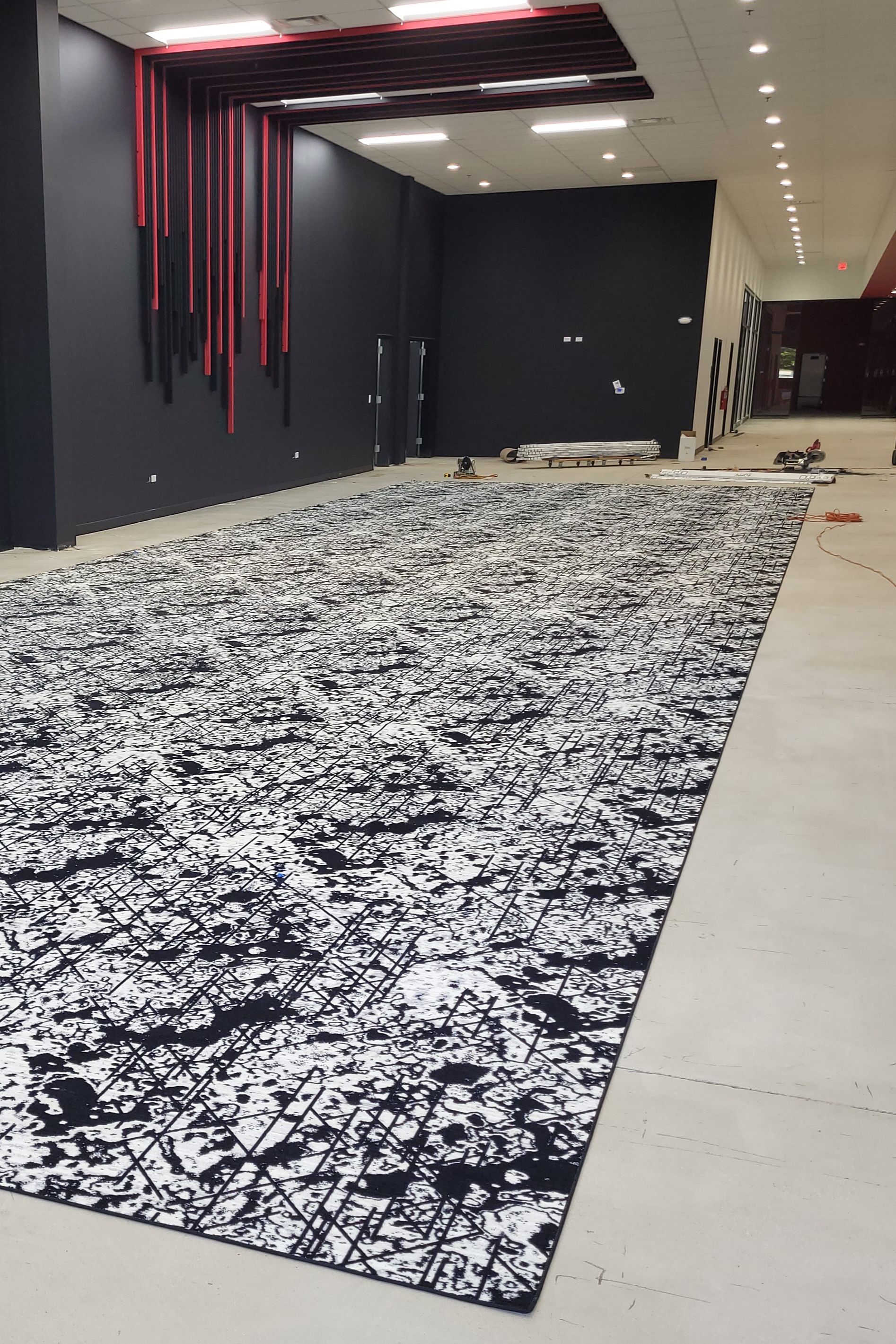 A Red Rug is Sitting on a Gray Carpet