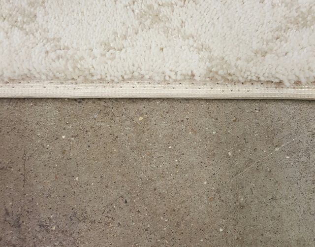 A Close Up of a Concrete Floor With a White Trim