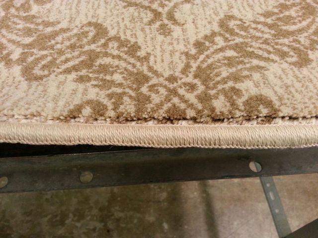 A Close Up of a Rug Sitting on Top of a Metal Frame