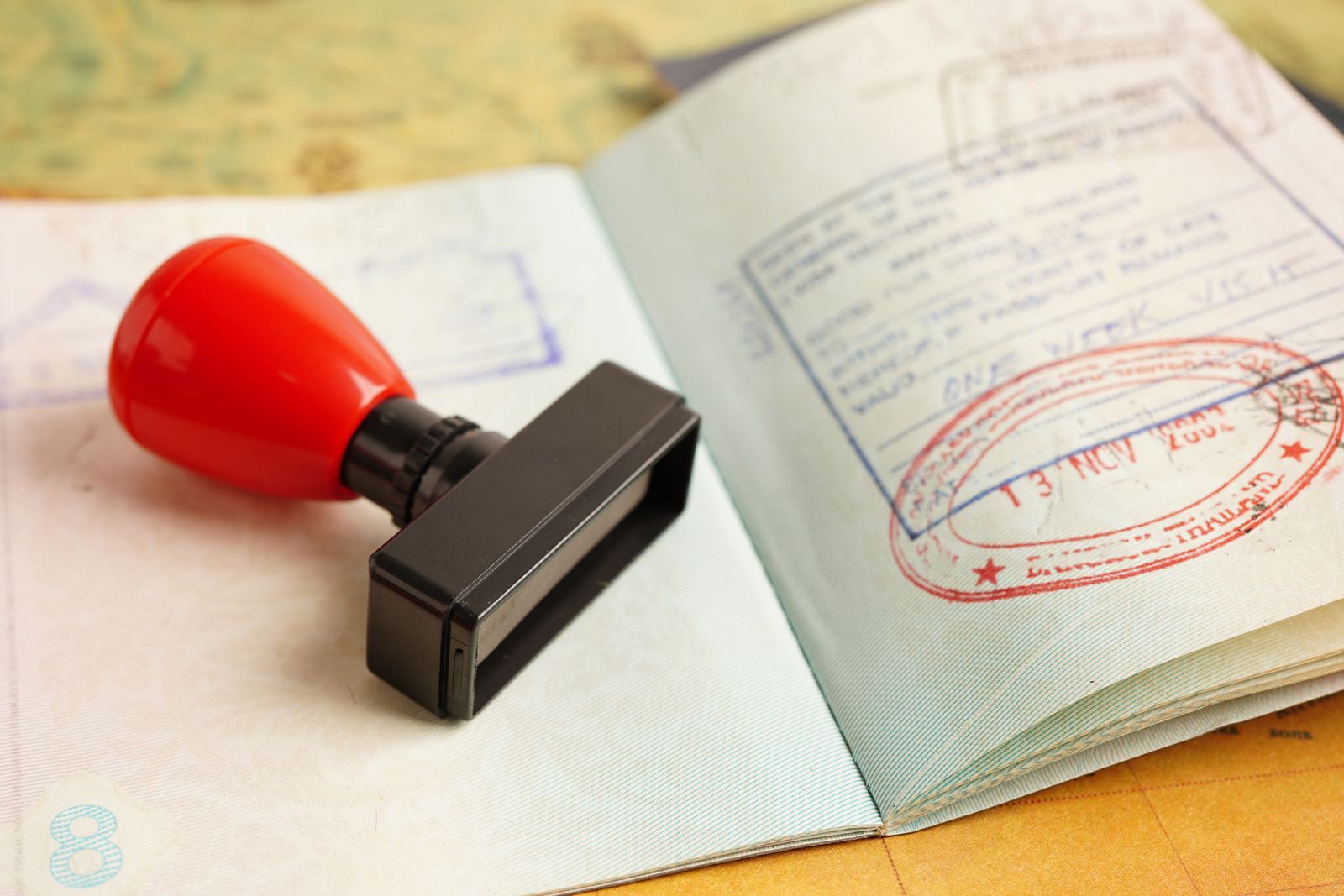 A red stamp is sitting on top of an open passport.