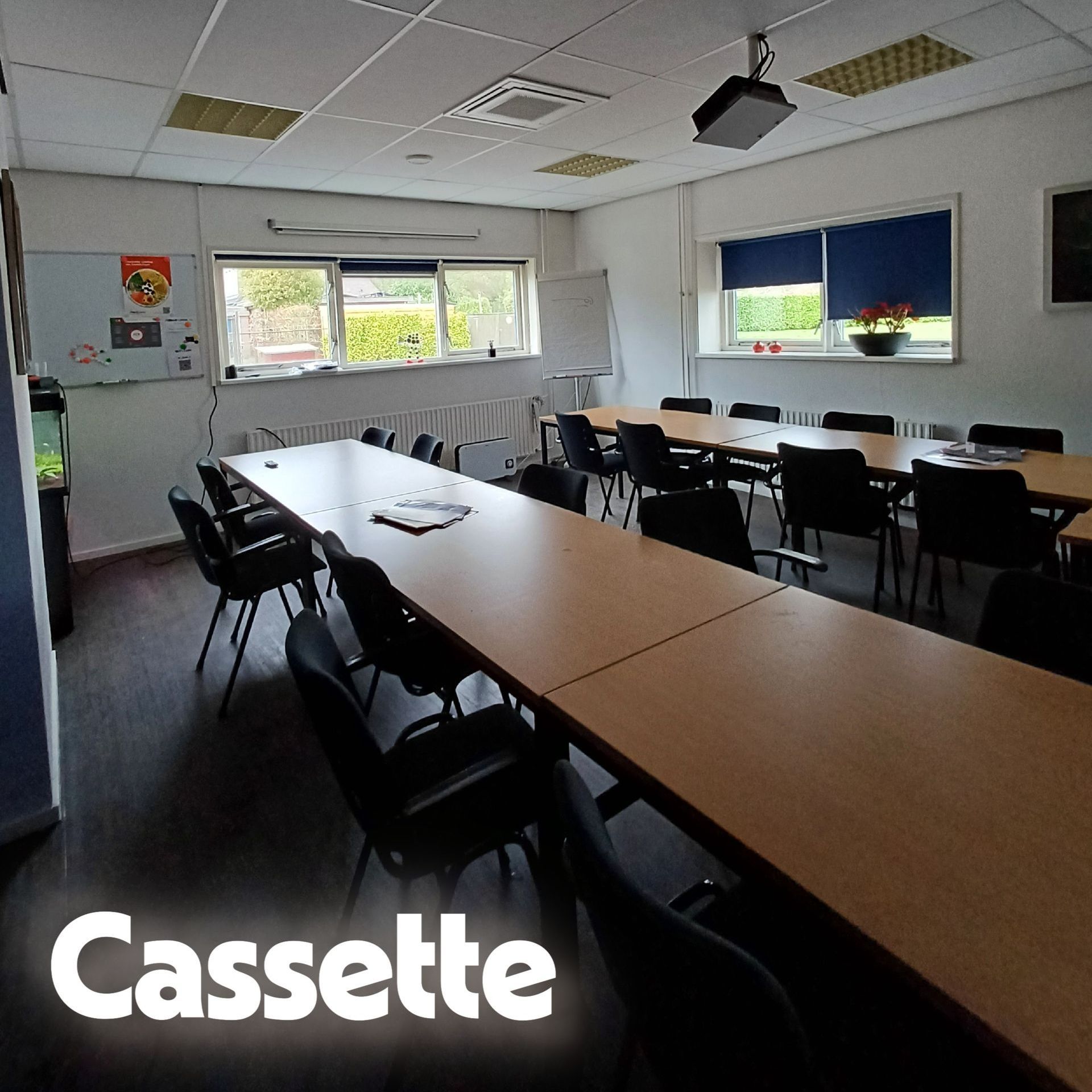 Kantoorruimte met systeemplafond waarin een cassette airco is geïnstalleerd, zichtbaar boven het bureau met computer en documenten.