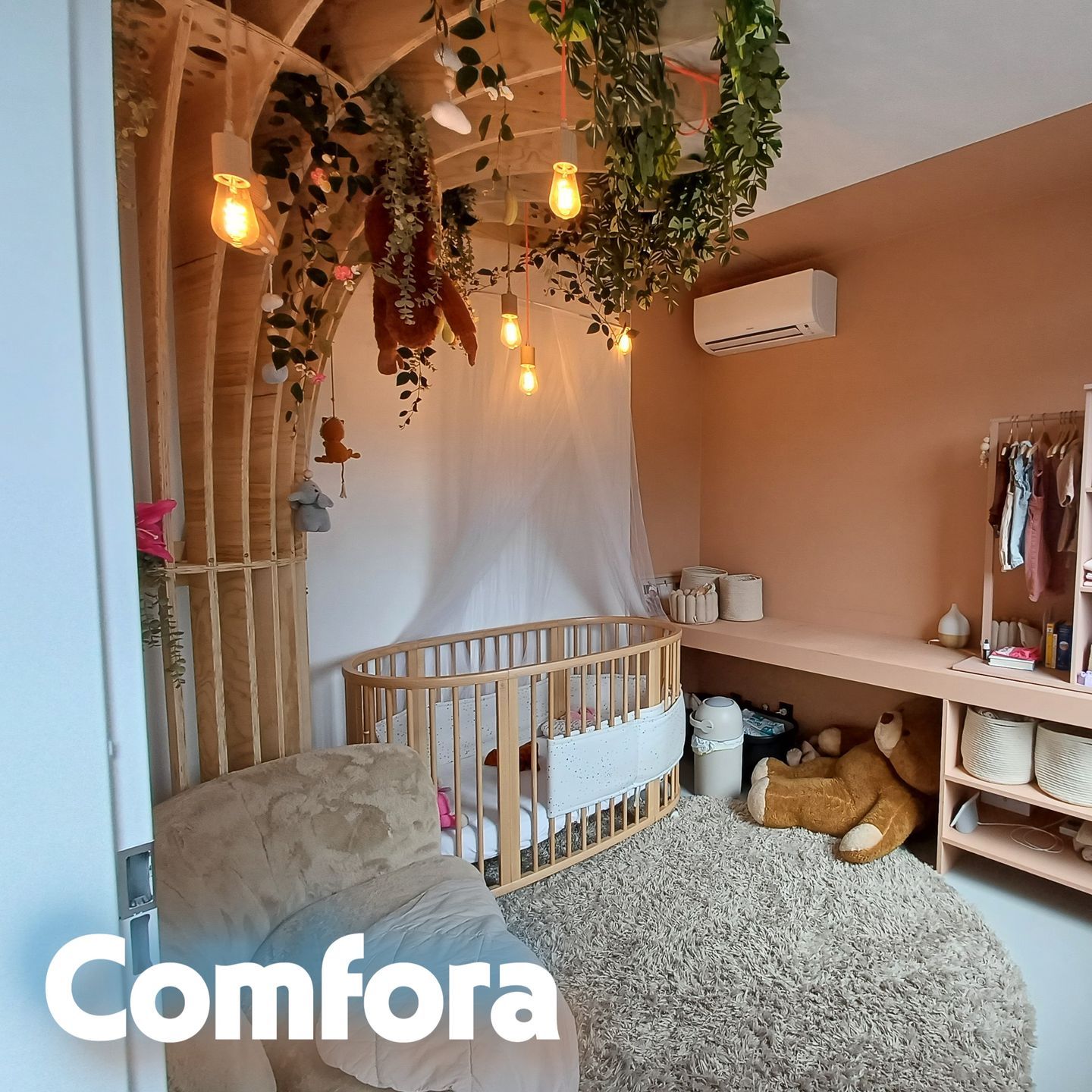 Kinderkamer met natuurlijke en warme inrichting, voorzien van een Daikin Comfora airco boven de commode en een ledikantje in bohemien stijl met sfeerverlichting en planten.
