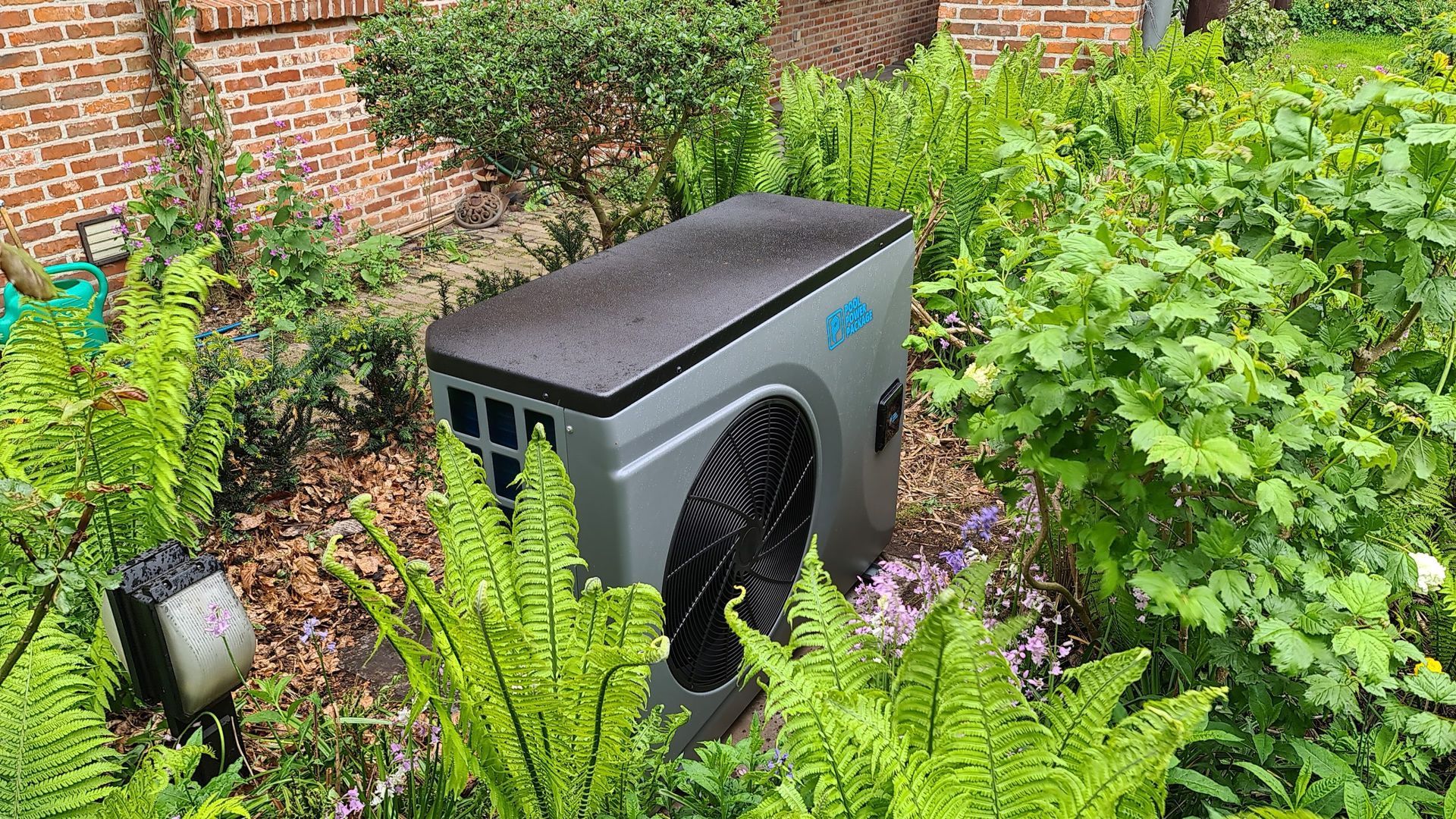 Een grote ventilator staat midden in een weelderige groene tuin.