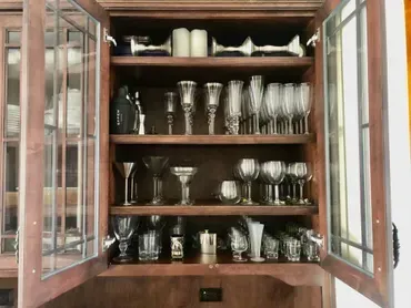 Wooden cabinet with glass doors filled with various stemware.