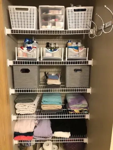 Organized closet with wire shelves; storage baskets and folded towels.
