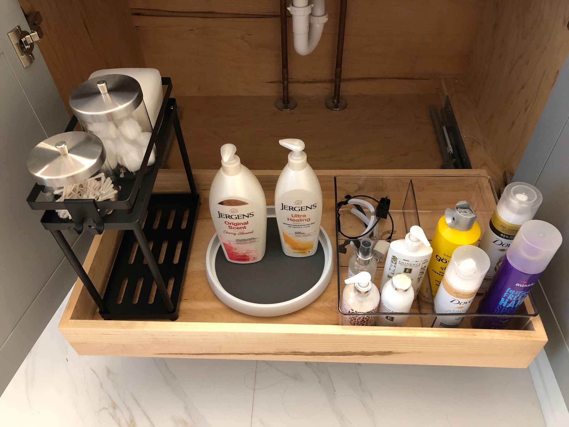 Bathroom cabinet storage with toiletries and cotton swabs.
