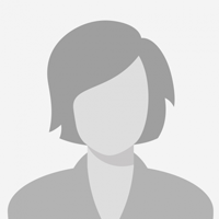 Woman with long dark hair smiles, leaning against a white doorframe. She wears a white shirt.