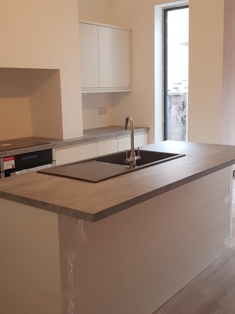 A kitchen with a sink , stove , and dishwasher.