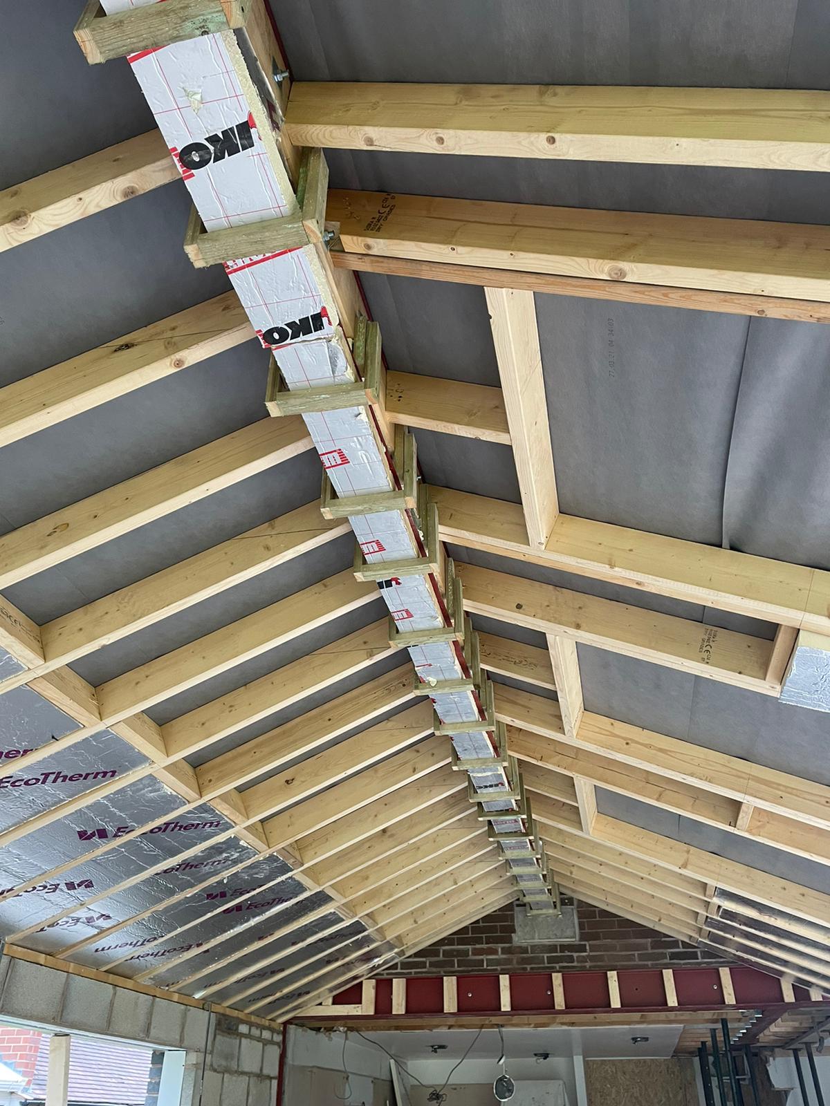 The ceiling of a building under construction with wooden beams.