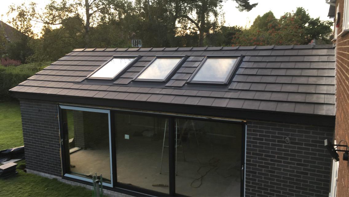 A brick building with a roof that has three skylights on it.