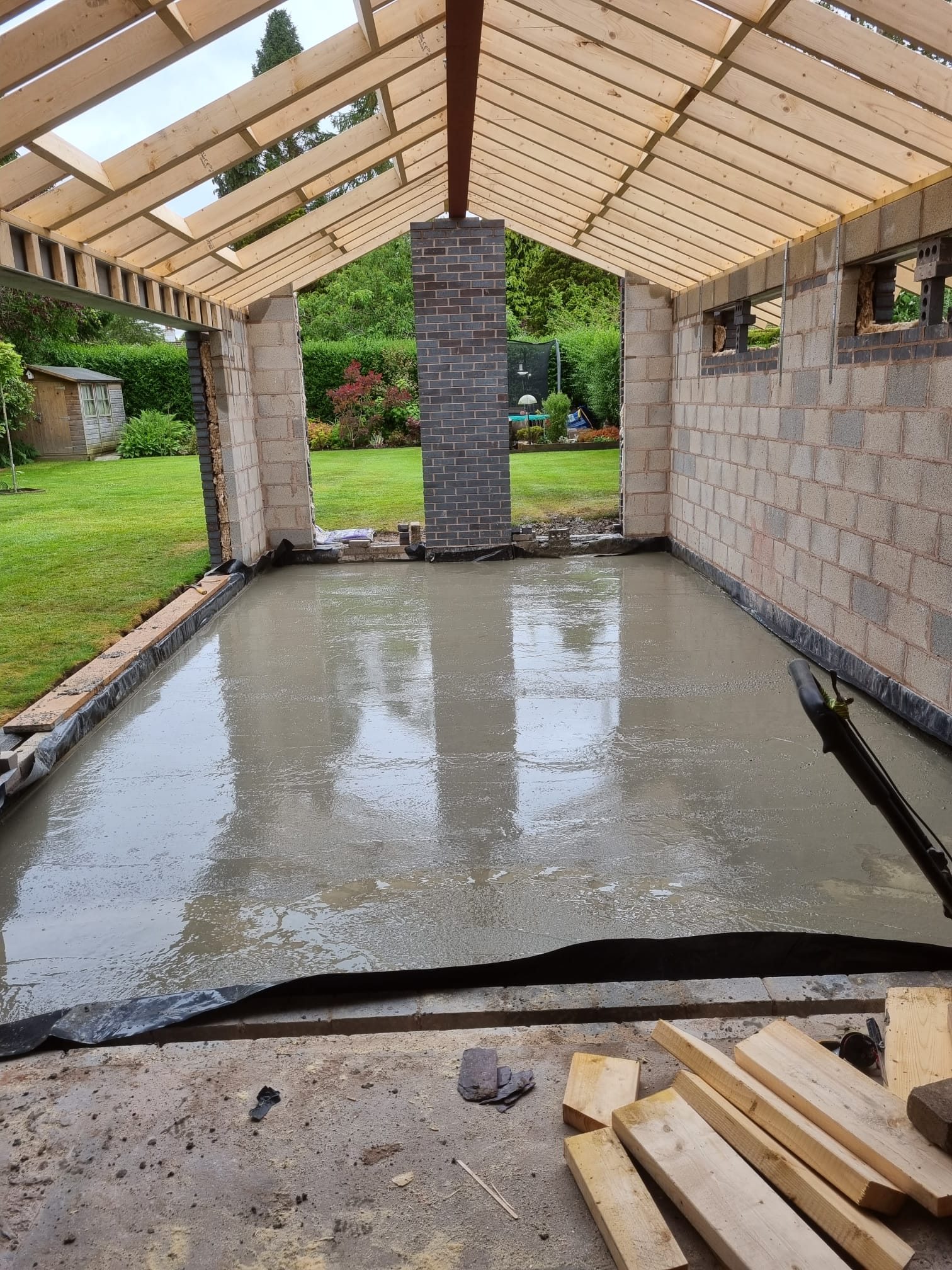 A concrete floor is being poured in a building under construction.