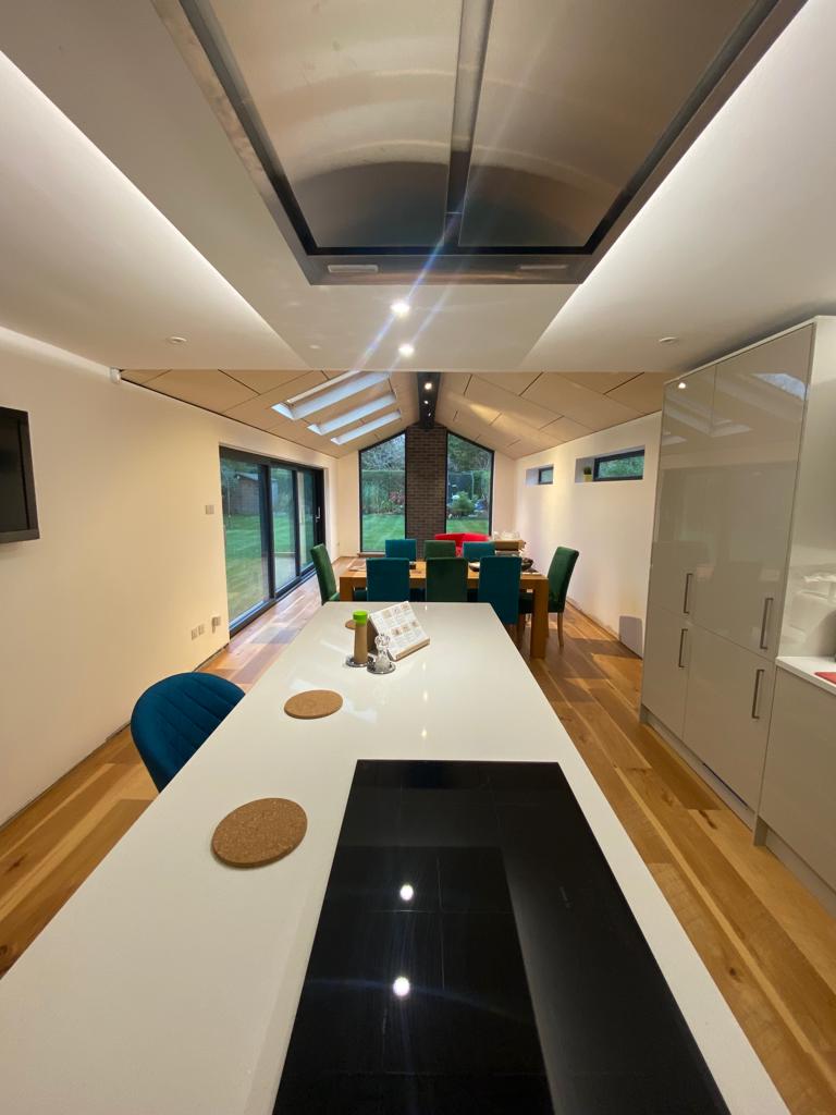 A kitchen with a table and chairs and a stove top oven.