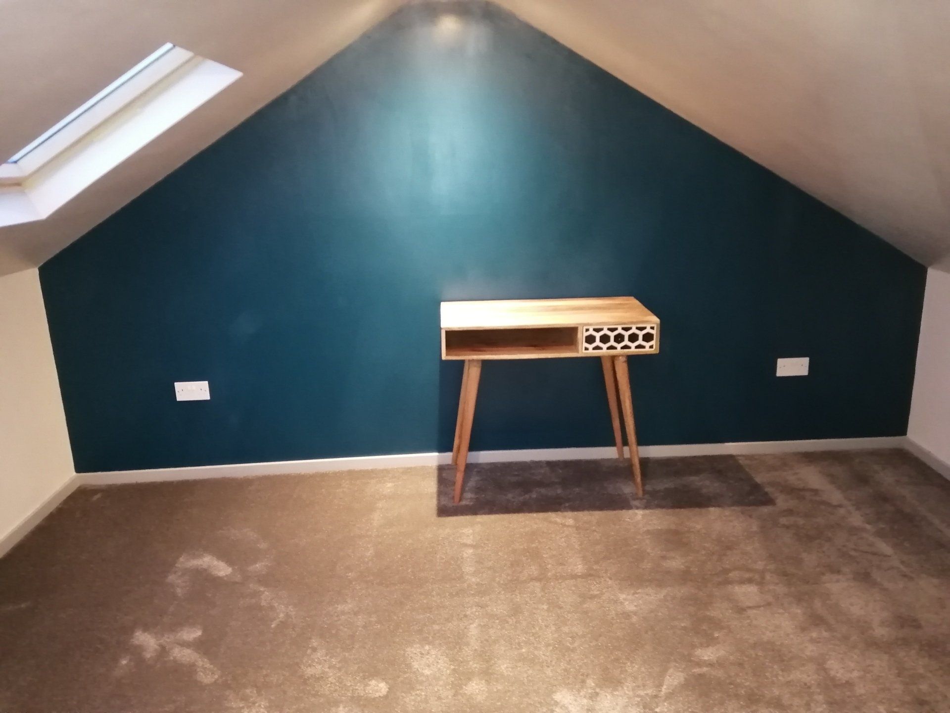 An empty room with a desk and a blue wall