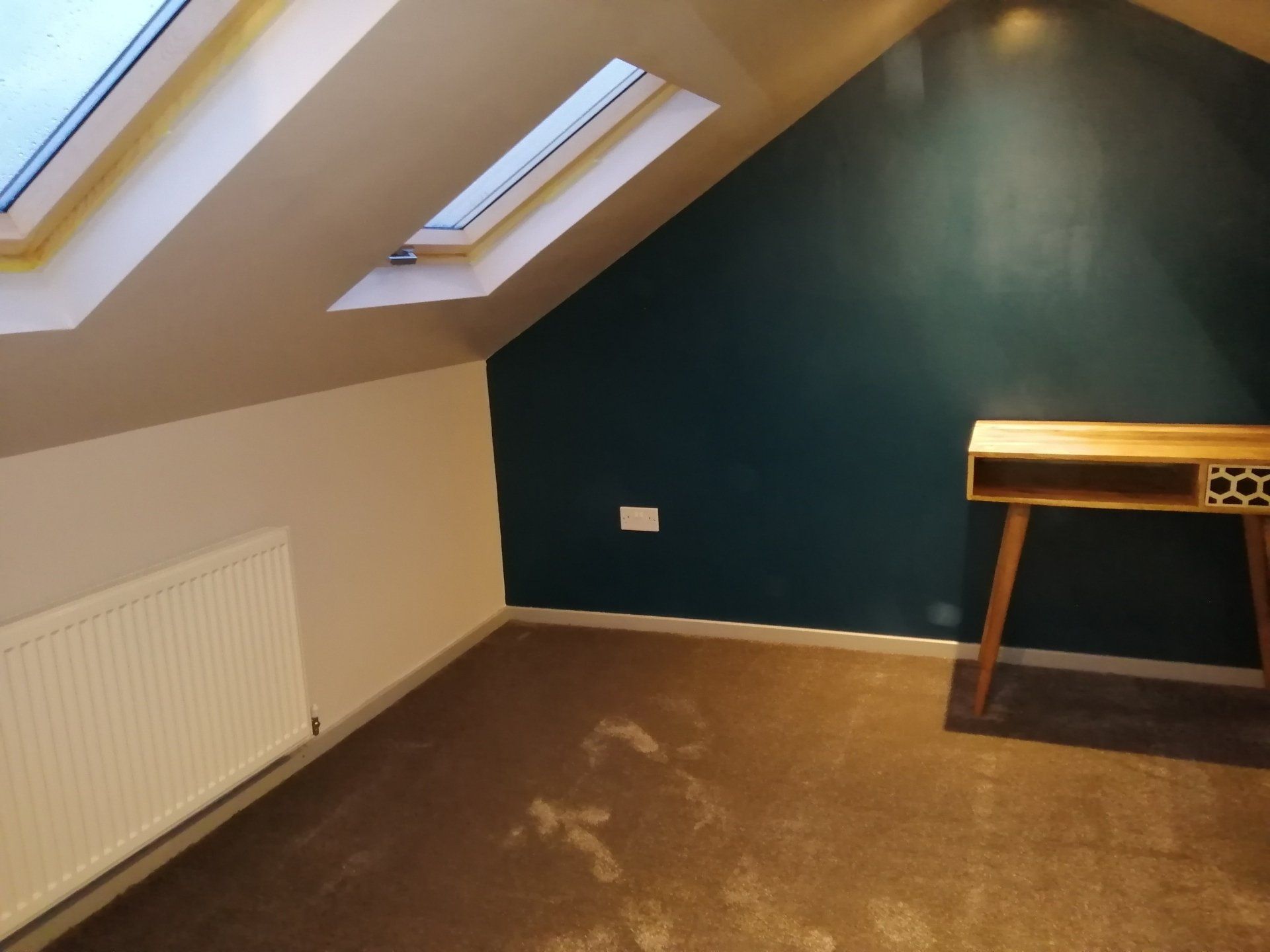 An empty room with a desk and a skylight