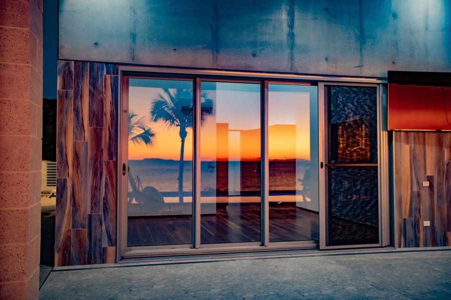 Sunset Reflection On Sliding Door — Peto's Constructions In Strathdickie, QLD