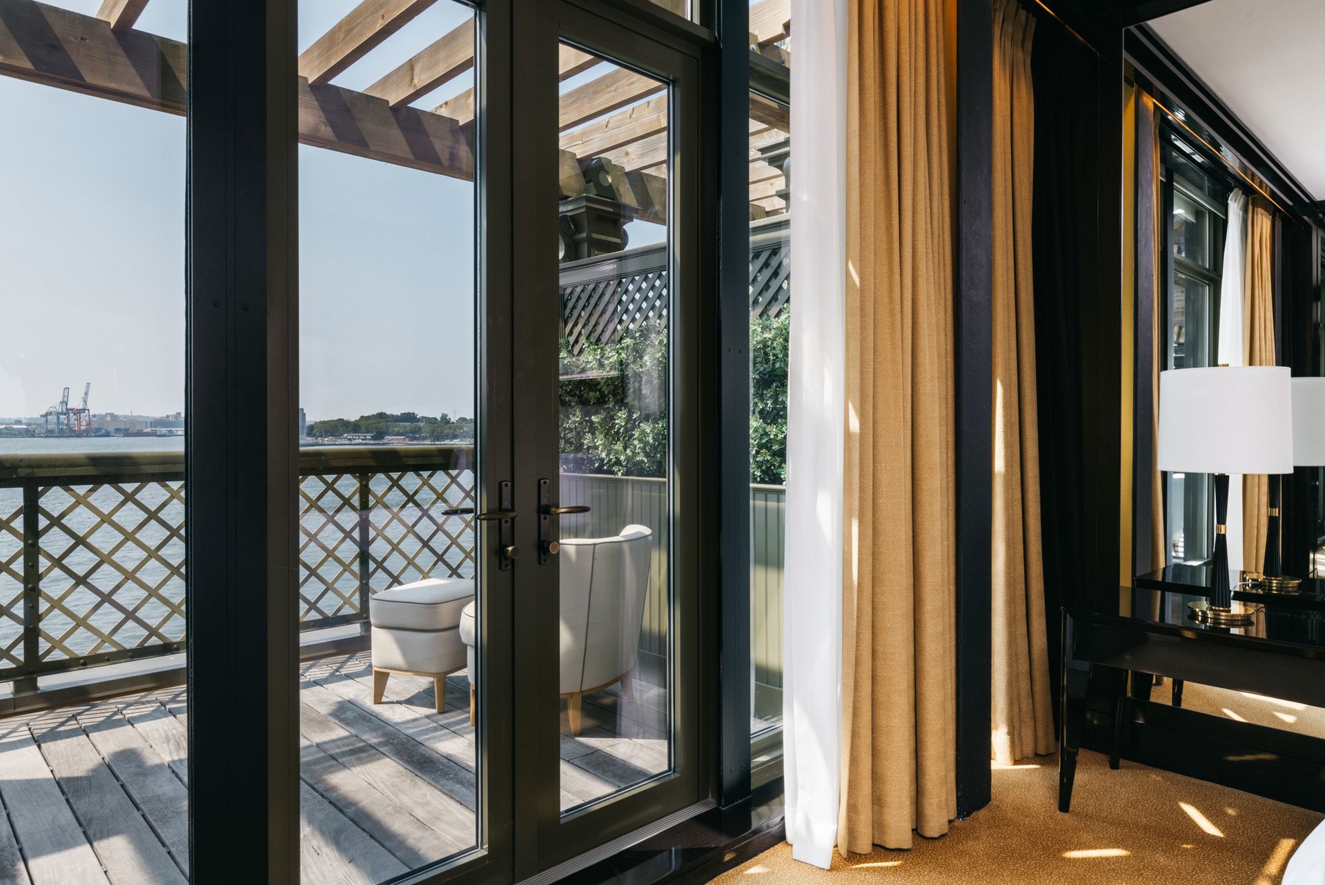 A hotel room with a balcony and a view of the ocean.