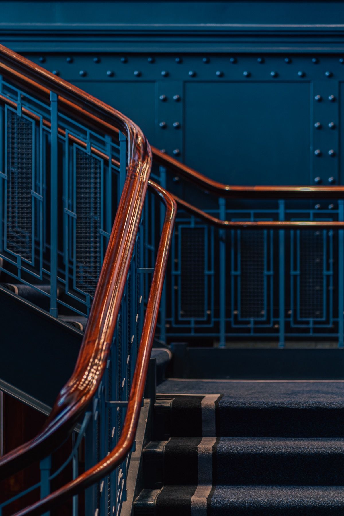 A staircase with a wooden railing and a blue wall.