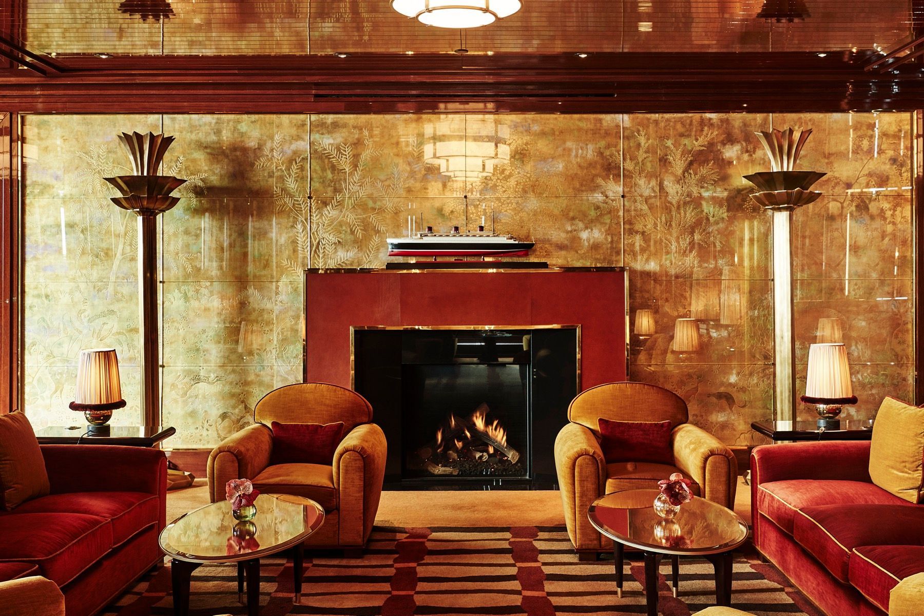 A living room with red furniture and a fireplace