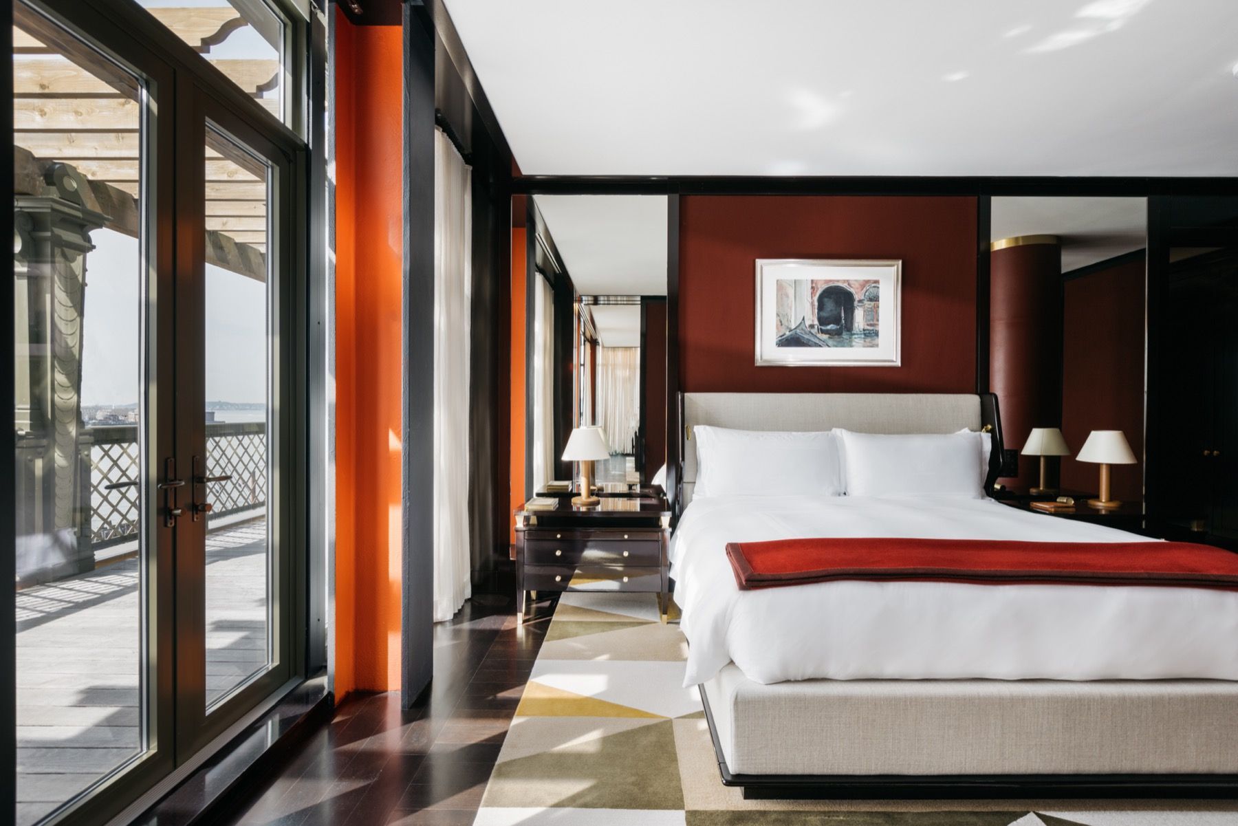 A bedroom with a large bed and lots of windows